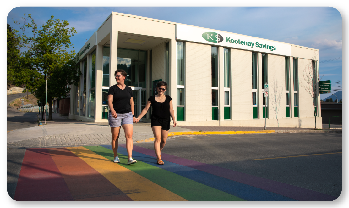 couple holding hands on pride crosswalk